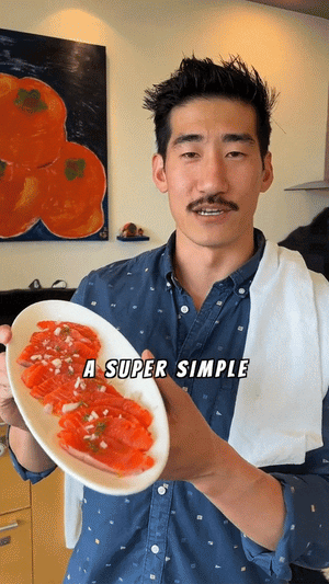 Man with mustache holding a plate of sliced salmon garnished with herbs and onions, text reads 'A SUPER SIMPLE'
