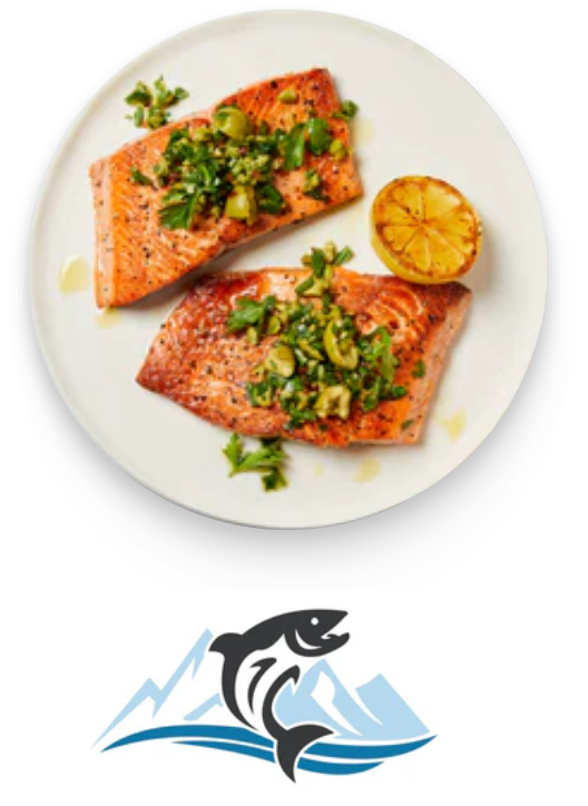 Two cooked salmon fillets garnished with herbs and a grilled lemon half on a white plate