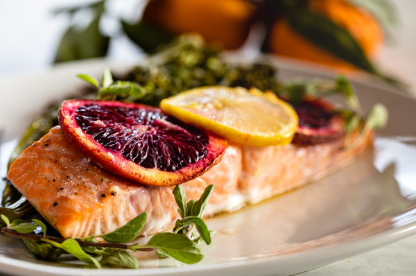 Seared Alaskan sockeye salmon topped with blood orange and lemon slices, served with greens