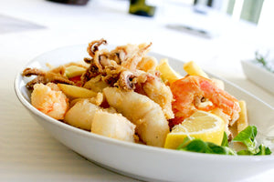 seafood with a slice of lemon in a ceramic plate