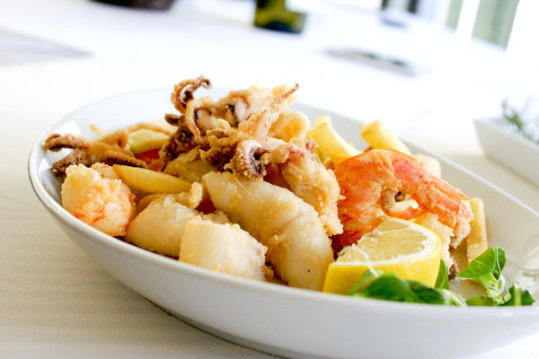 seafood with a slice of lemon in a ceramic plate